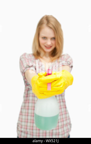 fair-haired woman holding a spray bottle against white background Stock Photo