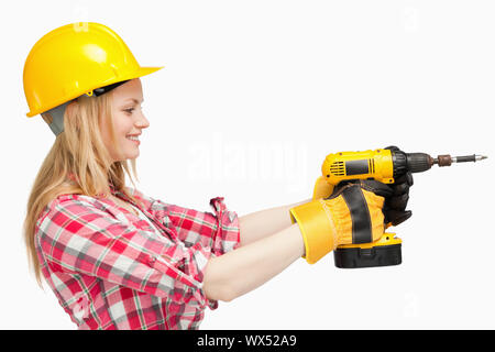 Woman using an electric screwdriver against white background Stock Photo