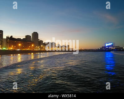 Mar del Plata, Buenos Aires Province - Argentina, 3rd August 2019: Fishers docking restaurant with famous Quilmes sign and skyline from Popular beach Stock Photo