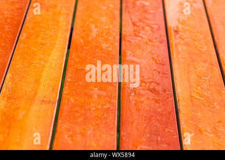 Raindrops on a varnished wooden garden table. Close-up, selective focus. Stock Photo