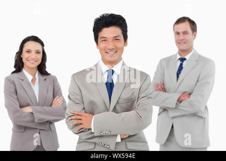 Smiling salesteam with arms folded against a white background Stock Photo