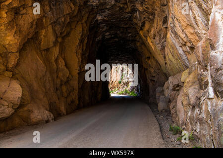 Tunnel and road curving through red rock sandstone - Gilman Tunnels near Jemez Springs in northern New Mexico Stock Photo