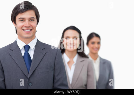 Smiling salesteam standing in line against a white background Stock Photo