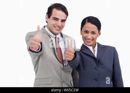 Smiling salespeople giving thumbs up against a white background Stock Photo