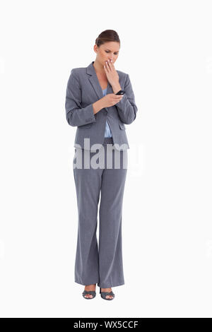 Tradeswoman being shocked by text message against a white background Stock Photo