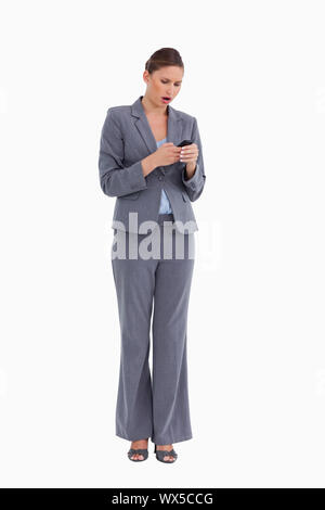 Shocked tradeswoman reading text message against a white background Stock Photo