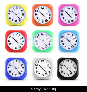 Set small alarm clocks in different colors on white background. Stock Photo