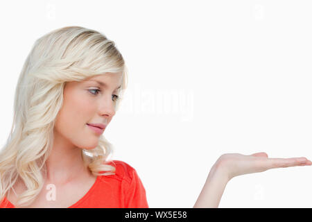 Beautiful woman placing her hand palm up against a white background Stock Photo