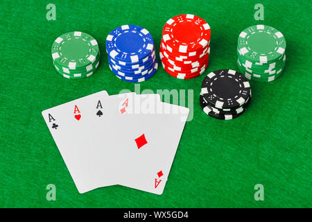 Casino chips and playing cards on green table Stock Photo