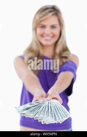 Fan of bank notes being held by a blonde woman against a white background Stock Photo