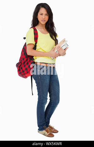 Beautiful Latin student with backpack holding textbooks against white background Stock Photo