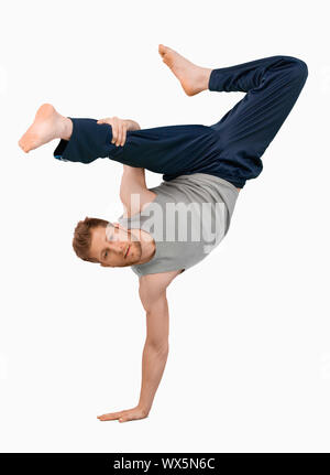 Break dancer doing an one handed handstand against a white background Stock Photo