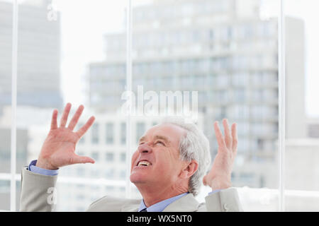 Angry senior manager raising his arms Stock Photo