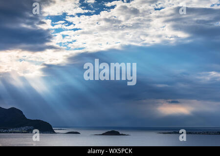 dramatic sky with sun rays over sea Stock Photo
