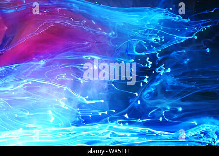 Blue and purple paints and inks swirling together in water abstract background Stock Photo