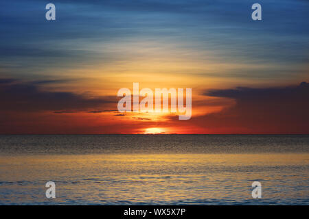 sunset over the ocean on clear evening Stock Photo
