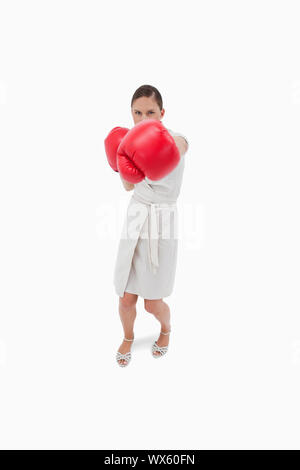 Portrait of a serious businesswoman punching someone against a white background Stock Photo