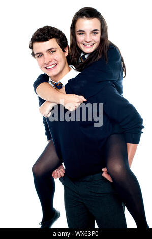 Girl riding piggyback and embracing boy tightly. All on white background Stock Photo