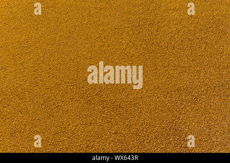 Painted rubber crumb surface. Rough colorful background. Yellow polyurethane material example. Copy space. Stock Photo