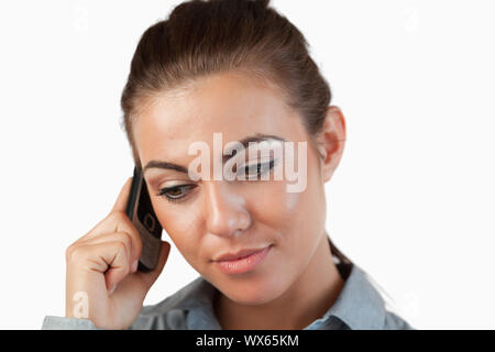Close up of businesswoman listening closely to caller against a white background Stock Photo