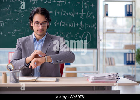 Young handsome math teacher in classroom Stock Photo