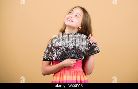 Acting school. Dances with fan. Girl fanning herself with fan. Air circulation. Art and culture. Handheld fan create airflow. Airflow from handfans increases evaporation. Cooling effect. Folding fans. Stock Photo