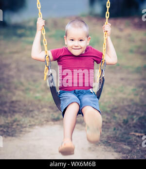 Little boy swinging on a swing Stock Photo
