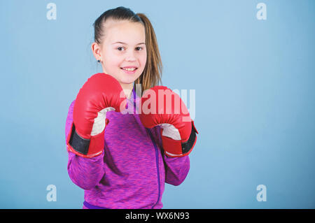 Rise of women boxers. Girl cute boxer on blue background. With great power comes great responsibility. Contrary to stereotype. Boxer child in boxing gloves. Female boxer change attitudes within sport. Stock Photo