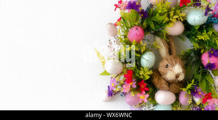 easter wreath with colorful eggs and flowers and a rabbit in the center Stock Photo