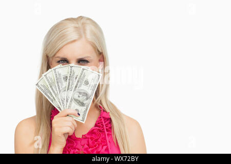 Woman hiding her face with 100 dollars banknotes against white background Stock Photo