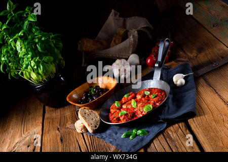 Baked mini meatballs in tomato sauce with basil Stock Photo