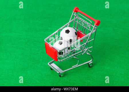 Soccer balls in shopping cart on foorbal field Stock Photo