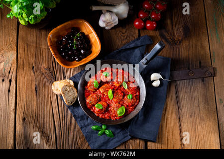 Baked mini meatballs in tomato sauce with basil Stock Photo