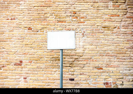 typical red brick wall background with blank white plaque Stock Photo