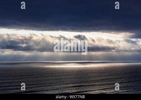 rays of sun through the clouds over ocean Stock Photo