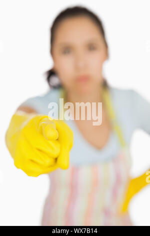 Woman in apron and gloves pointing accusingly ahead Stock Photo