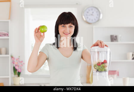 Charming brunette female posing while standing in the kitchen Stock Photo