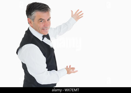 Well-dressed man showing us something with open arms Stock Photo