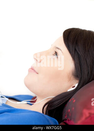 Charming teen girl listening music lying on a sofa Stock Photo - Alamy
