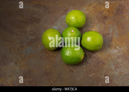 Freshly lime fruits on trendy rust background Stock Photo