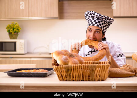 Young male baker working in kitchen Stock Photo