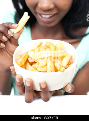 Young woman eating fries against a white background Stock Photo