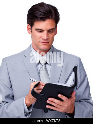 Concentrated businessman consulting his agenda against a white background Stock Photo