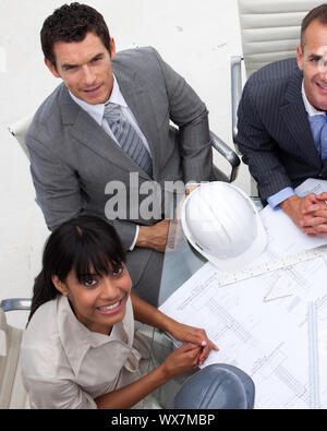 High angle of multi-ethnic architects working with blueprints in an office Stock Photo