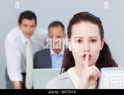 Portrait of a young businesswoman asking for silence in the office Stock Photo