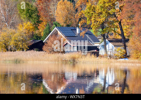 house at the lake with solar panels on the roof Stock Photo