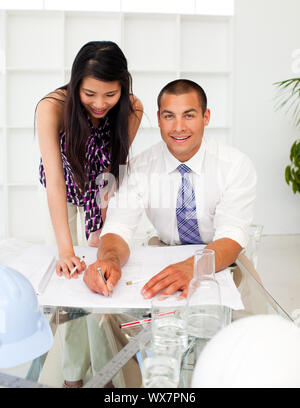A diverse group of architects reviewing blueprints in a meeting Stock Photo