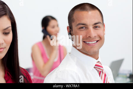 Smiling businessman with headset on at work Stock Photo