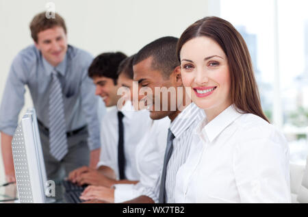 Brunette businesswoman and her team working at computers Stock Photo
