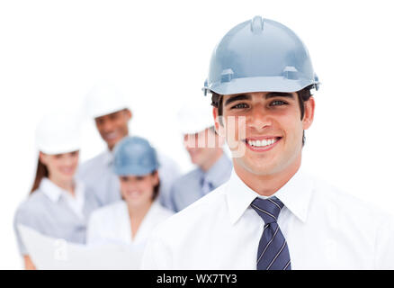 Focus on a male architect wearing a hardhat in front of his team Stock Photo